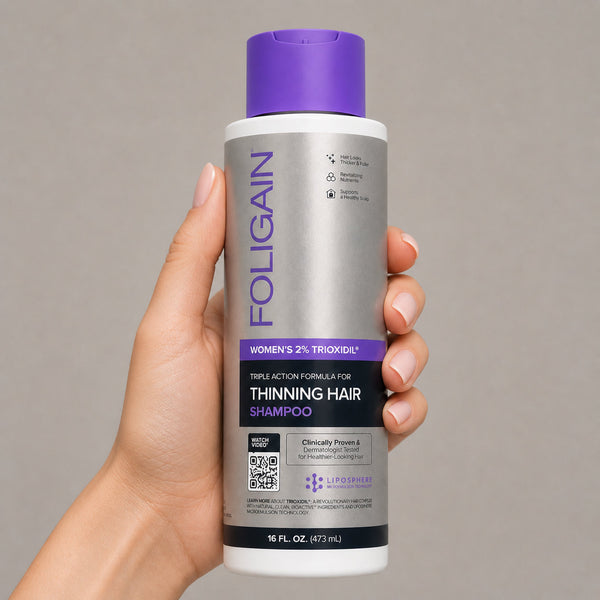 FOLIGAIN Triple Action Conditioner for thinning women's hair with 2% TRIOXIDIL, 473ml bottle, shown in a natural setting.