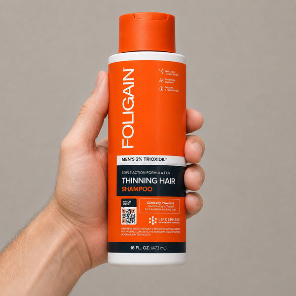 FOLIGAIN Triple Action Shampoo for thinning men's hair with 2% TRIOXIDIL in a 473ml bottle, shown in hand.